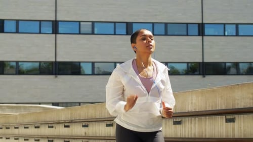 African American Woman with Earphones Running