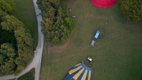 Aerial View of Hot Air Balloons Prepare for an Summer Early Morning Flying in Park in Small European