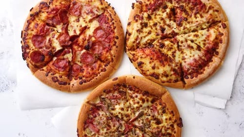 Three Delicious Pizzas with Various Toppings