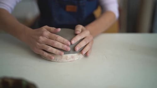 Close up female potter modeling clay bowl in workshop - Artisan work and creative craft concept
