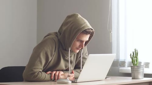 Junger Hacker konzentrierte sich auf Coding Hacker mit Blick auf die Bildschirmüberwachung Stock Online