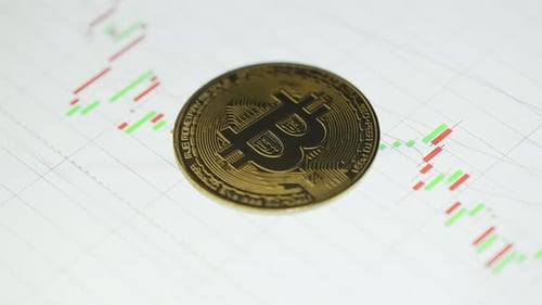 Golden Bitcoin Coin on Red and Green Graph