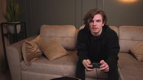 Young Adult Playing Video Game on Couch
