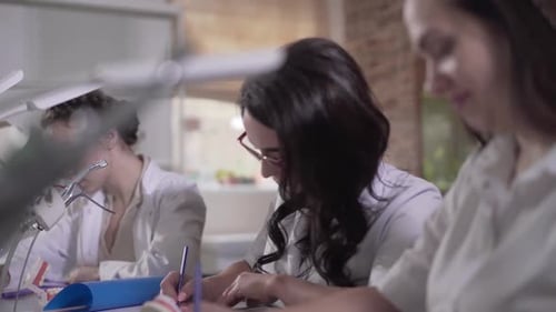 Close-up of Female Caucasian Dentistry Students in White Uniform Writing Test on Stomatology