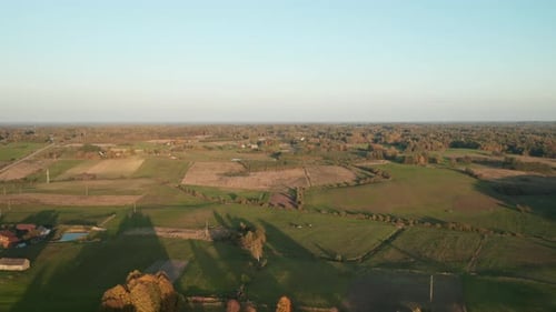 AERIAL: Nature Landscape with Green Plains and Forest with Sky in Background
