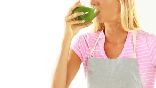 Blonde Woman Drinking a Green Smoothie Indoors