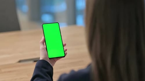 Rear View of Businesswoman using Smartphone with Green Chroma Key Screen