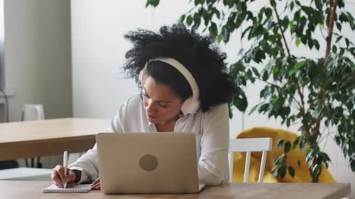 Young Woman Working on Laptop with Headphones