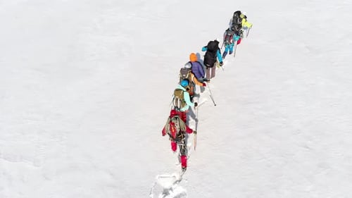 Ein großer, schneebedeckter Hügel, der knietief versucht, eine Gruppe ausgebildeter Bergsteiger zu finden