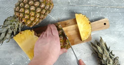 Cutting Fresh Pineapple on Wooden Cutting Board