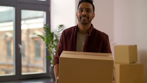 Young Adult Carrying Box Inside New Home
