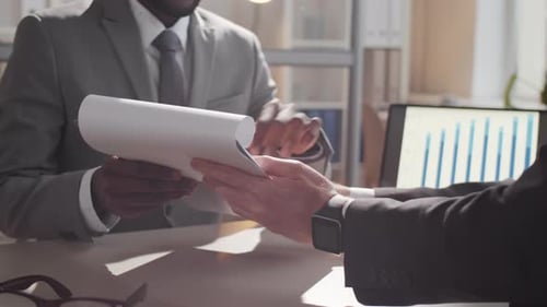 Close Up of Two Multiethnic Business Partners Signing Contract
