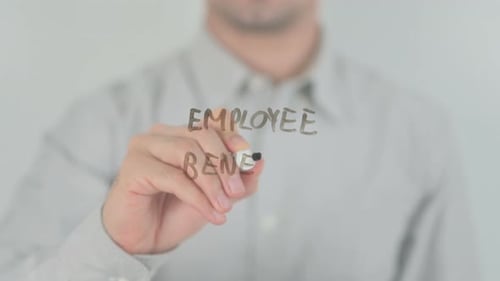 Hand Writes Employee Benefit on Transparent Surface