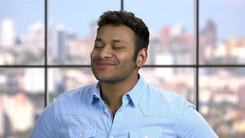 Smiling Man in Front of a City Window