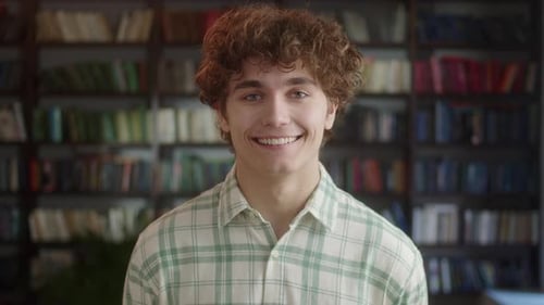Portrait of Attractive Man Student Standing in Front of the Camera and Laughing in High School