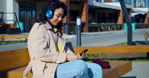 Woman Listening to Music on Phone Outdoors