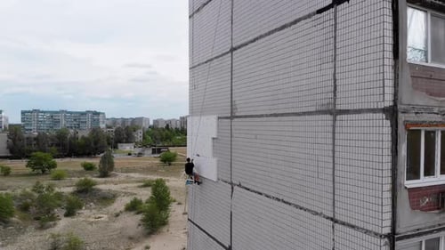 Industrial Alpinism. Aerial View. Work on Outer Insulate Building with Styrofoam