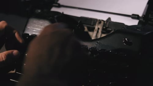 Nahaufnahme eines Mannes, der auf einer alten Retro-Schreibmaschine tippt