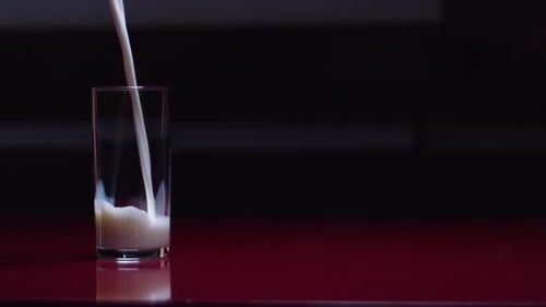Slow motion shot of milk being poured into a glass