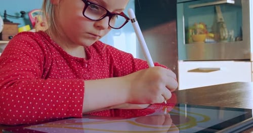 Child Draws on Tablet with Digital Pen Indoors