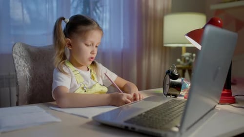 Little Girl Drawing with Laptop at Desk
