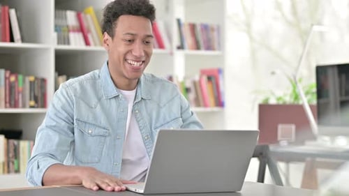 Young Adult at Computer Typing and Waving