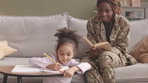 Soldier Reading with a Young Girl Writing at Home