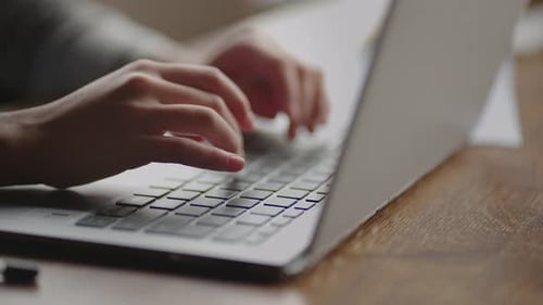 Fingers Typing on Silver Laptop Keyboard Close Up