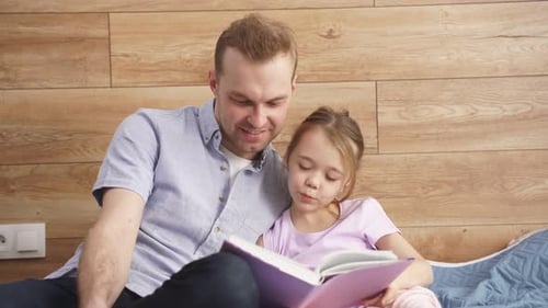 Dad and Daughter Reading a Book Together