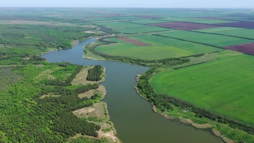 Landwirtschaftliche Felder und Wälder am Ufer des Stausees.