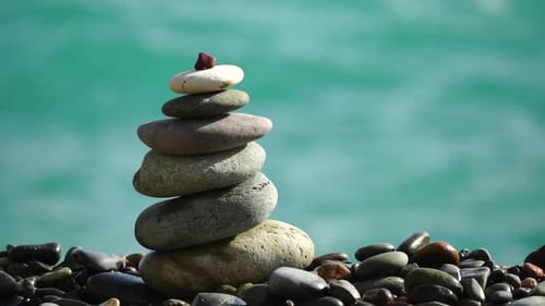 Balanced Pebbles Pyramid on the Beach on Sunny Day and Clear Sky at Sunset