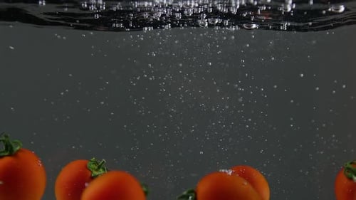 Cherry Tomatoes Plunging into Clear Refreshing Water