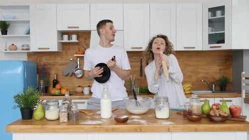 Enthusiastic Couple Singing and Dancing in Kitchen