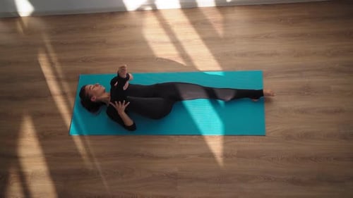 Woman Stretching on Yoga Mat in Sunlight