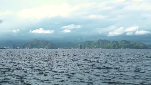 Picturesque View of City Buildings and Hills From Moving Ferry in the Sea.
