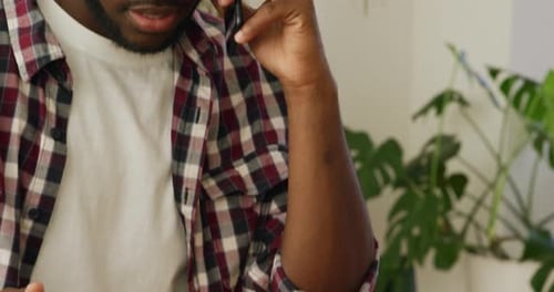 Man at home using smartphone and tablet