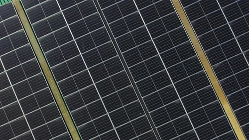 4K Aerial view of solar cell panels on building rooftop.