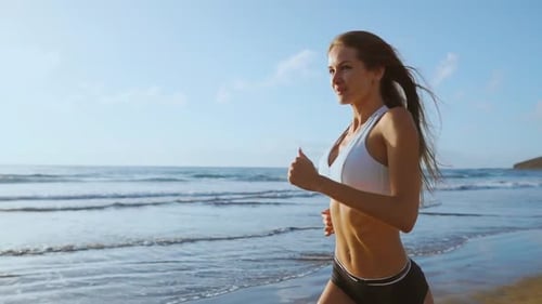 a Young Woman with a Slender Figure Is Engaged in Gymnastics at Sea at Sunrise. She Makes a Run