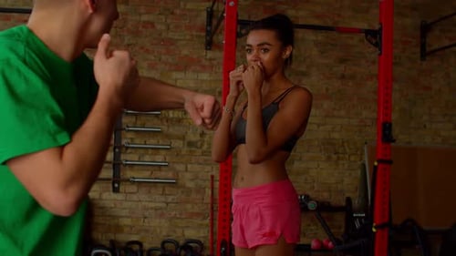 Woman Trains in Boxing with Gym Instructor