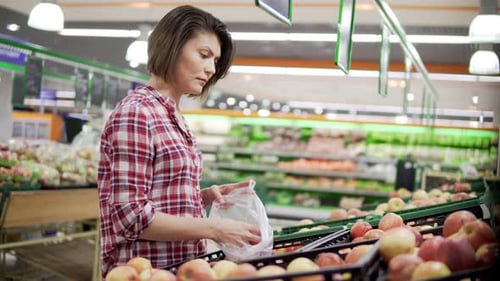 Beautiful Woman Shopping Red Apples in Supermarket