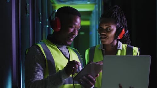Engineers Analyzing Data in Dark Server Room