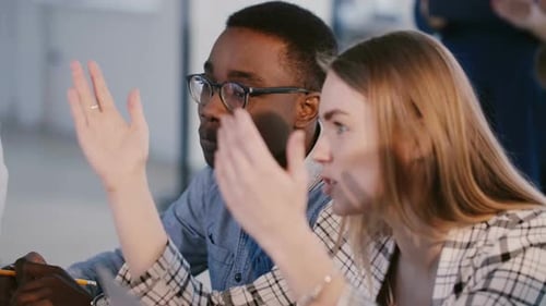 Young Positive Mixed Race Business People, Man and Woman, Cooperate Discussing Project Behind Table