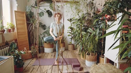 Woman Practicing Yoga Balance Pose with Indoor Plants