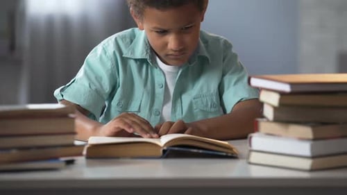 Frustrated Boy Studying at a Table with Books