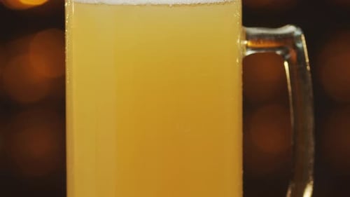 Glas voll Bier steht auf der Arbeitsplatte und schwenkt Nahaufnahme.