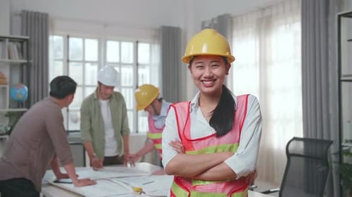 Woman Engineer Crossing Arms And Smiling To Camera While His Colleagues Are Discussing About Work