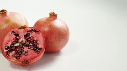 Granatapfel mit Halbstück auf weißem Hintergrund 4K 4k