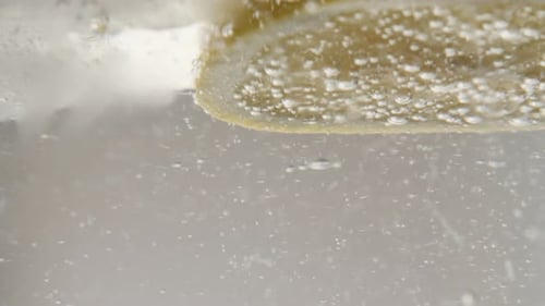 Close-up of carbonated water glass with ice cubes and lemon refreshing beverage 4K 2160p 30fps Ultra