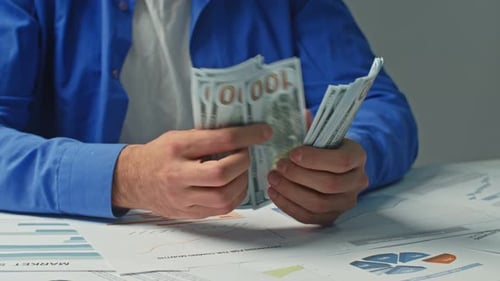 Closeup of a Businessman Counting Money and Beating His Fist on the Table