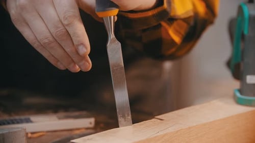 Carpentry - a Man Woodworker Cutting Out the Recess on the Wooden Block with a Chisel